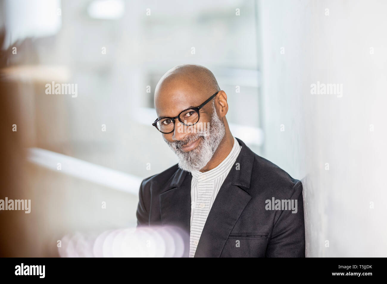 Portrait of bald mature businessman with grey beard wearing glasses ...