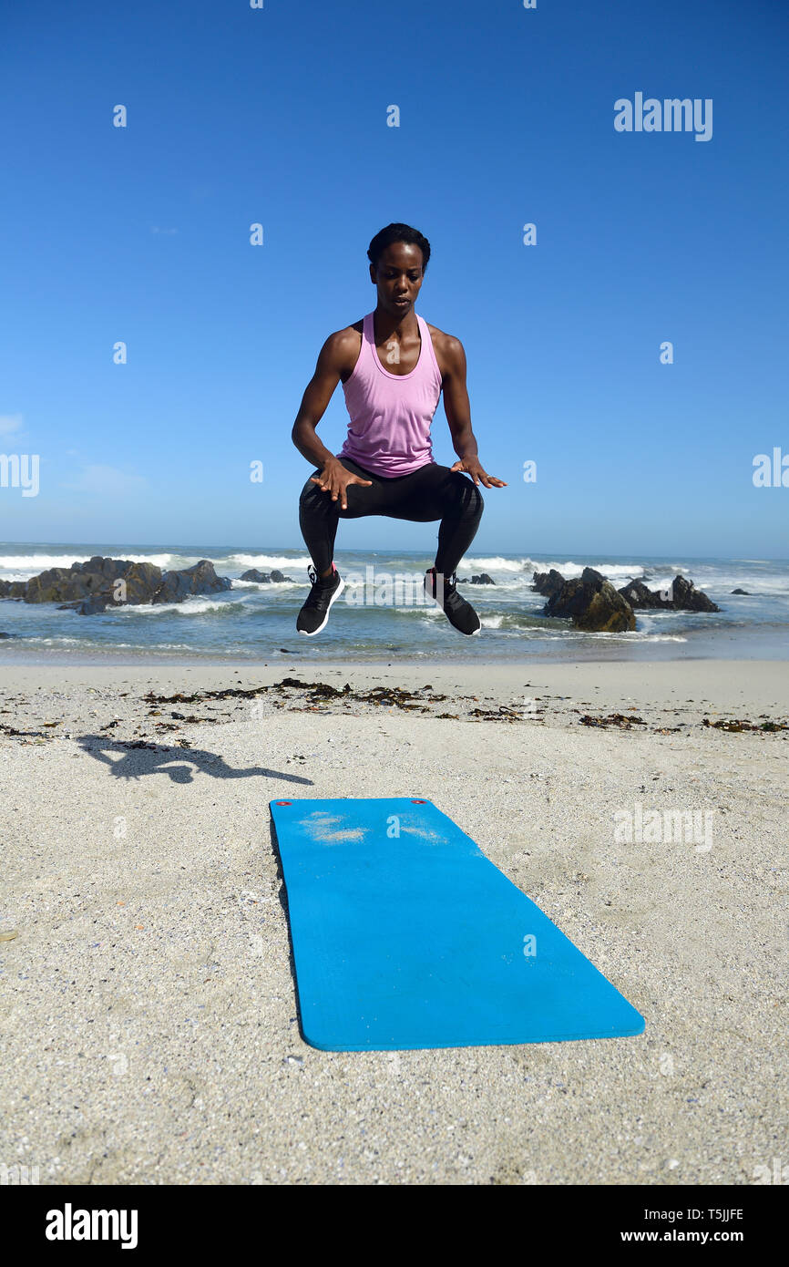 Sportive woman jumping on the beach Stock Photo Alamy