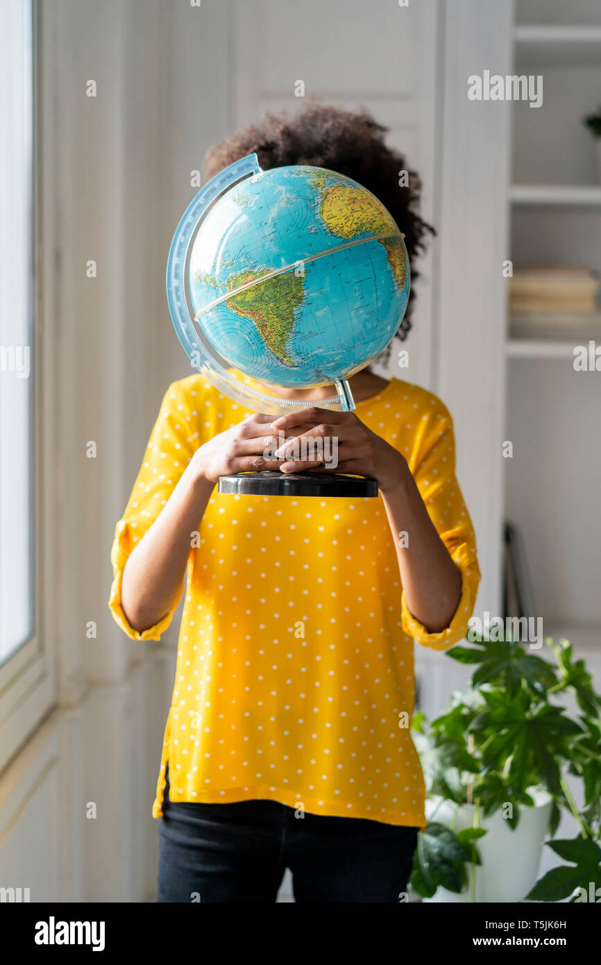 Woman holding globe, hiding face Stock Photo