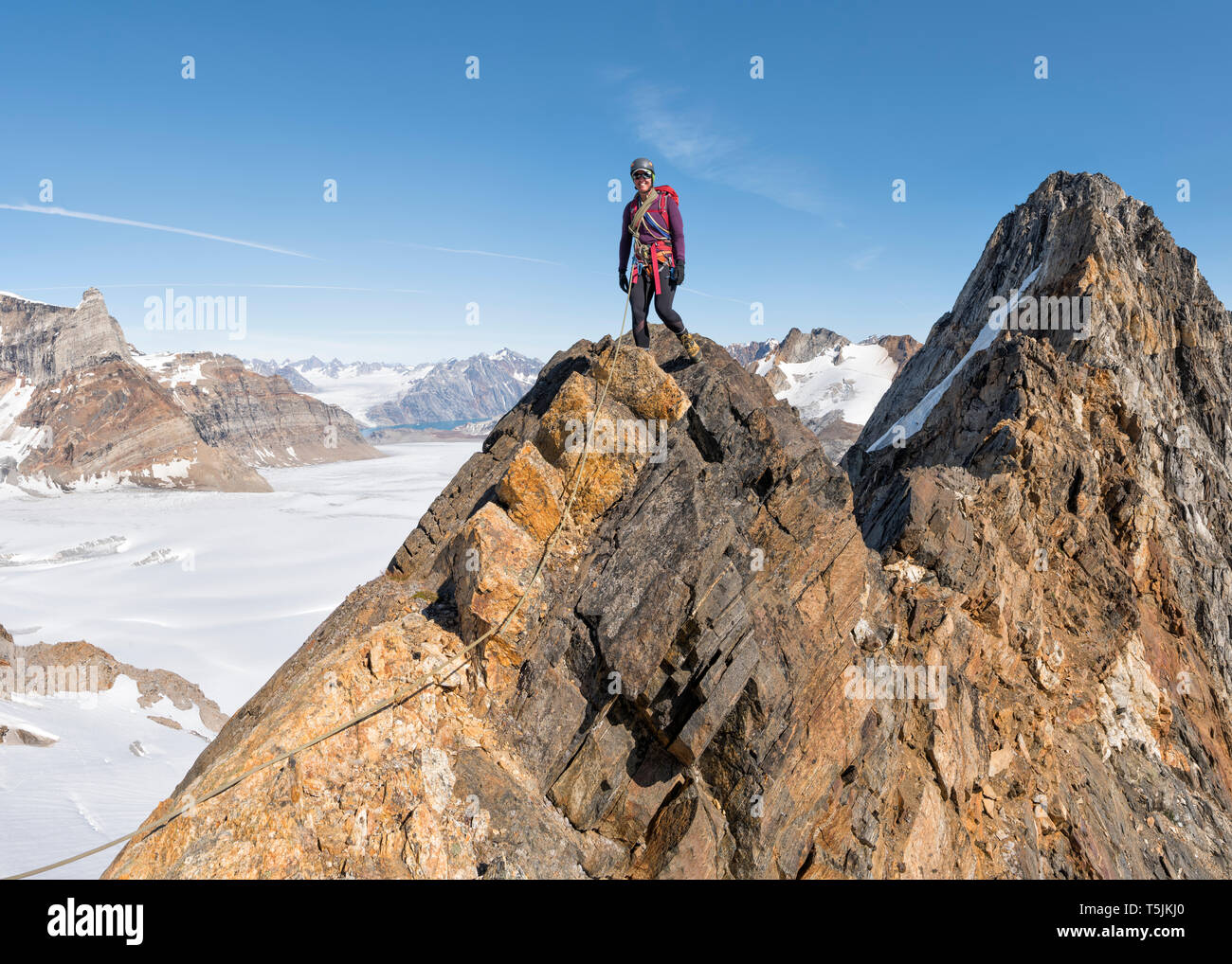 Greenland, Sermersooq, Kulusuk, Schweizerland Alps, smiling mountaineer on summit Stock Photo