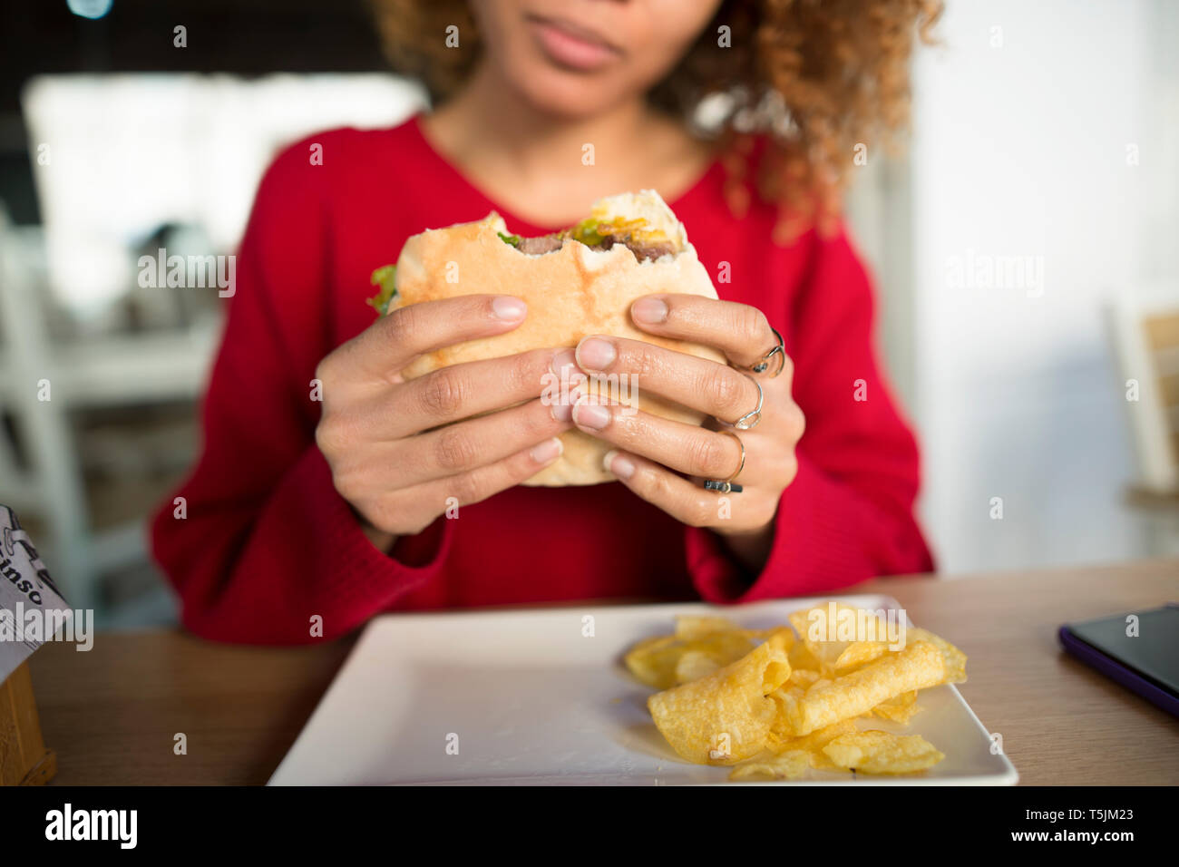 Close-up of woman's hands holding a hamburger Stock Photo