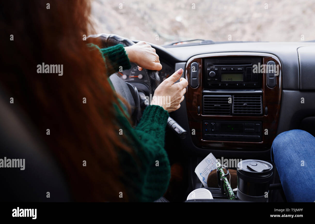 Back view of woman driving car on mountian road Stock Photo