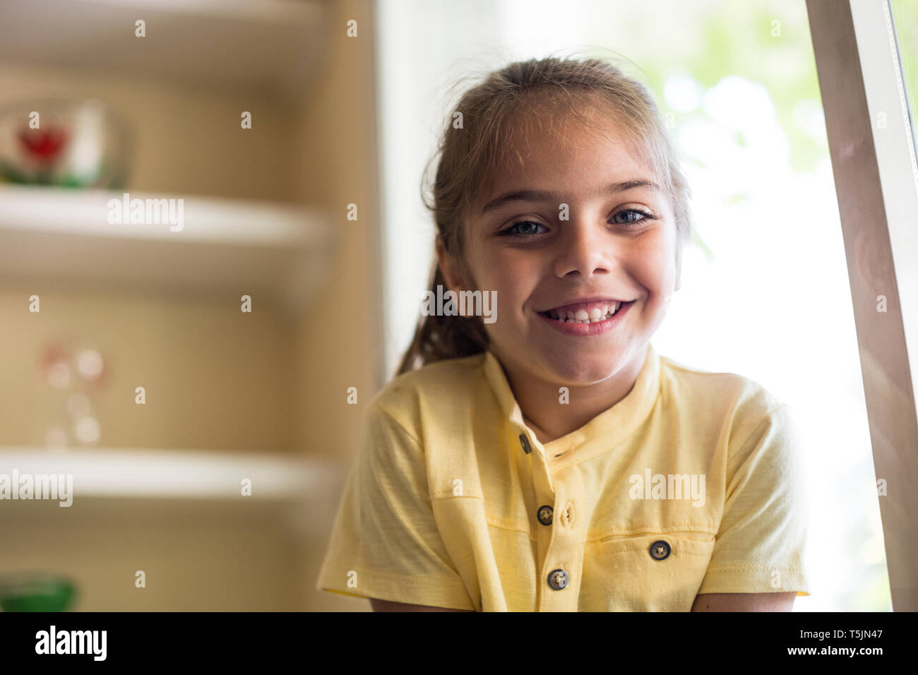 Portrait of smiling little girl at home Stock Photo - Alamy