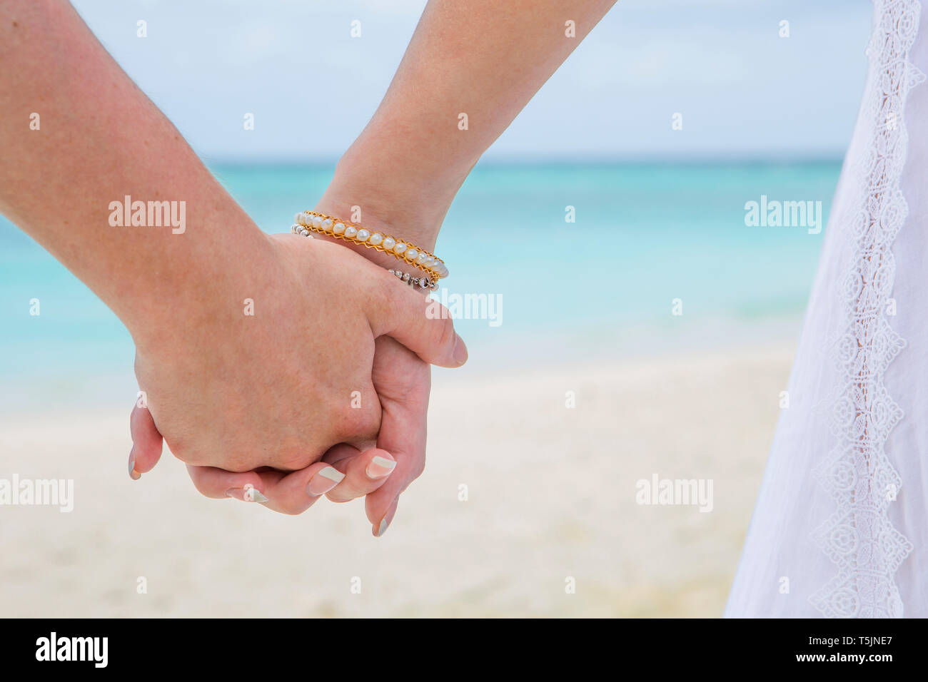 Couple holding hands at the beach, close up Stock Photo