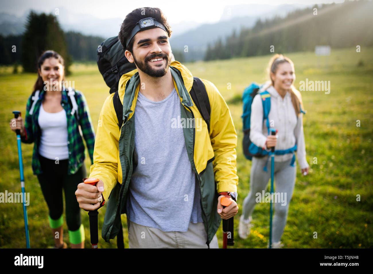 Group of young friends hiking in countryside. Multiracial young people ...