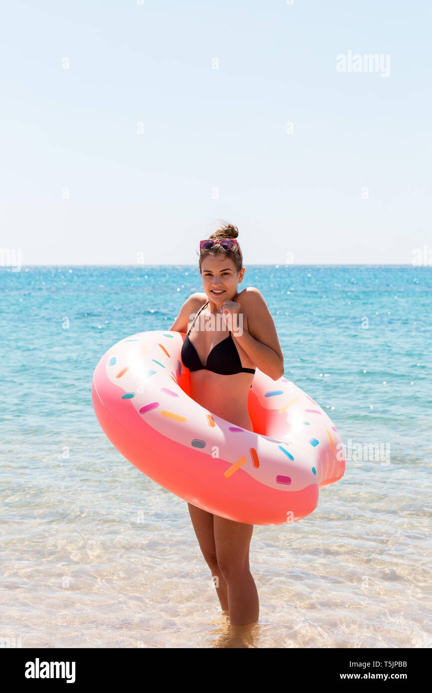 Young woman with inflatable ring cold shivering sad crossed arms black bikini  swimsuit standing in sea water. Summer holidays and vacation concept Stock  Photo - Alamy