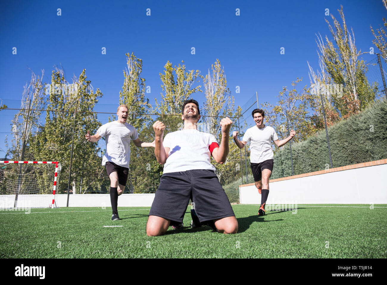 Football player celebrating a goal on the grass during a match Stock Photo