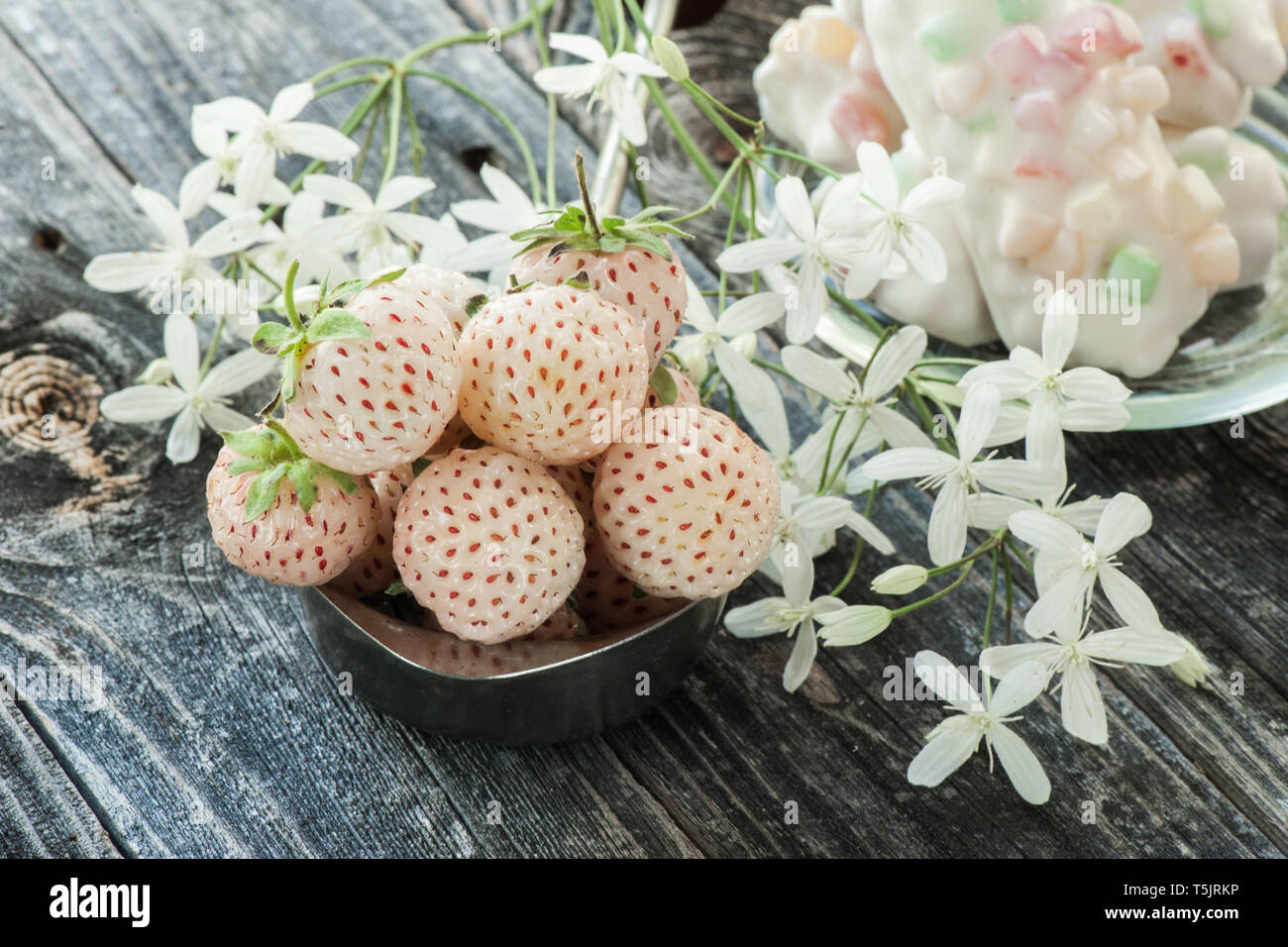 Pineberry Ripe Ripe fresh pineberries in a pink Cup in a rustic style with small white ...