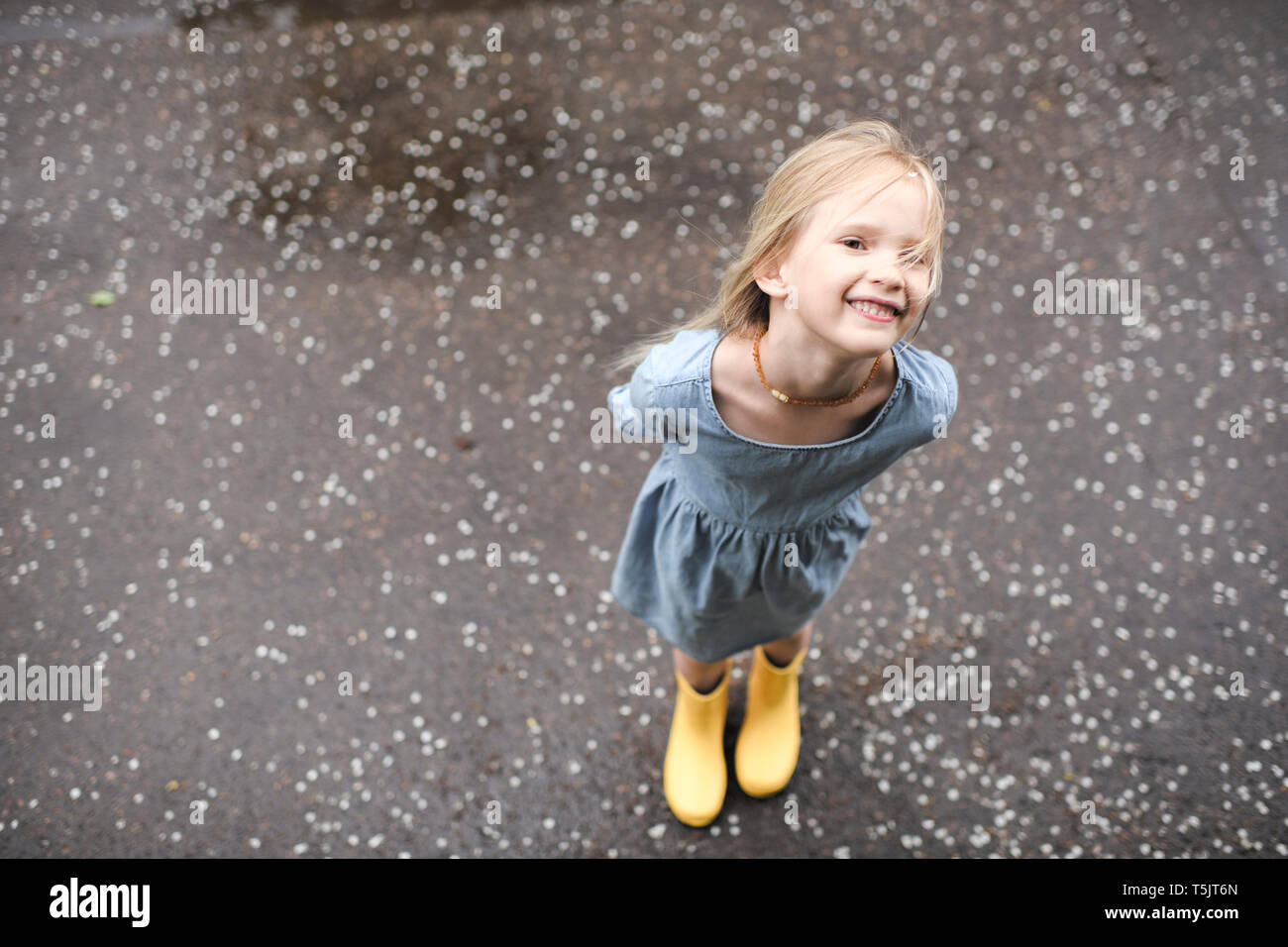 Girl wearing blue dress and rubber boots Stock Photo