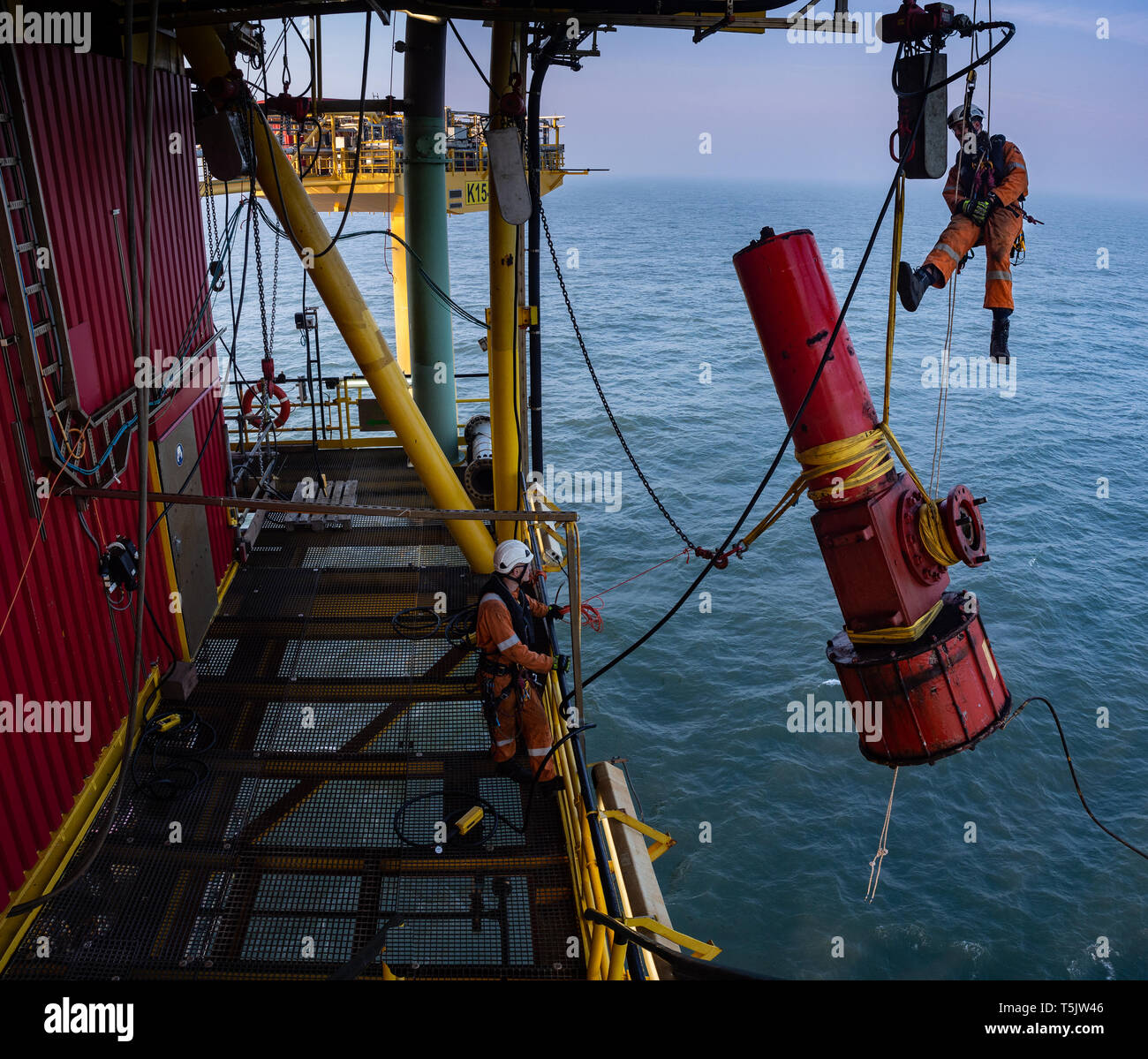 Abseilers rigging equipment on offshore platform Stock Photo