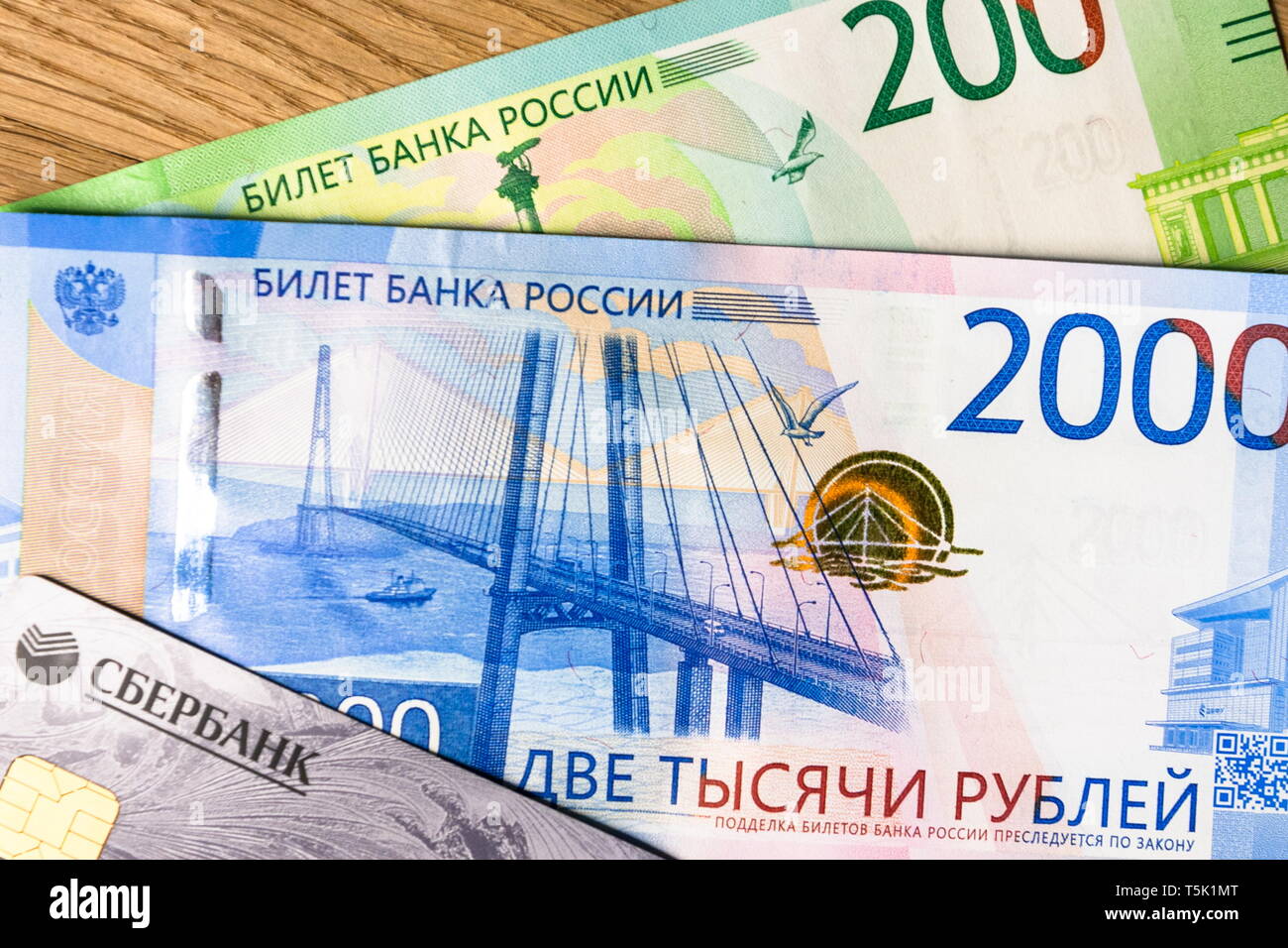 Money and sberbank credit card on a woody background. Rubles Stock Photo