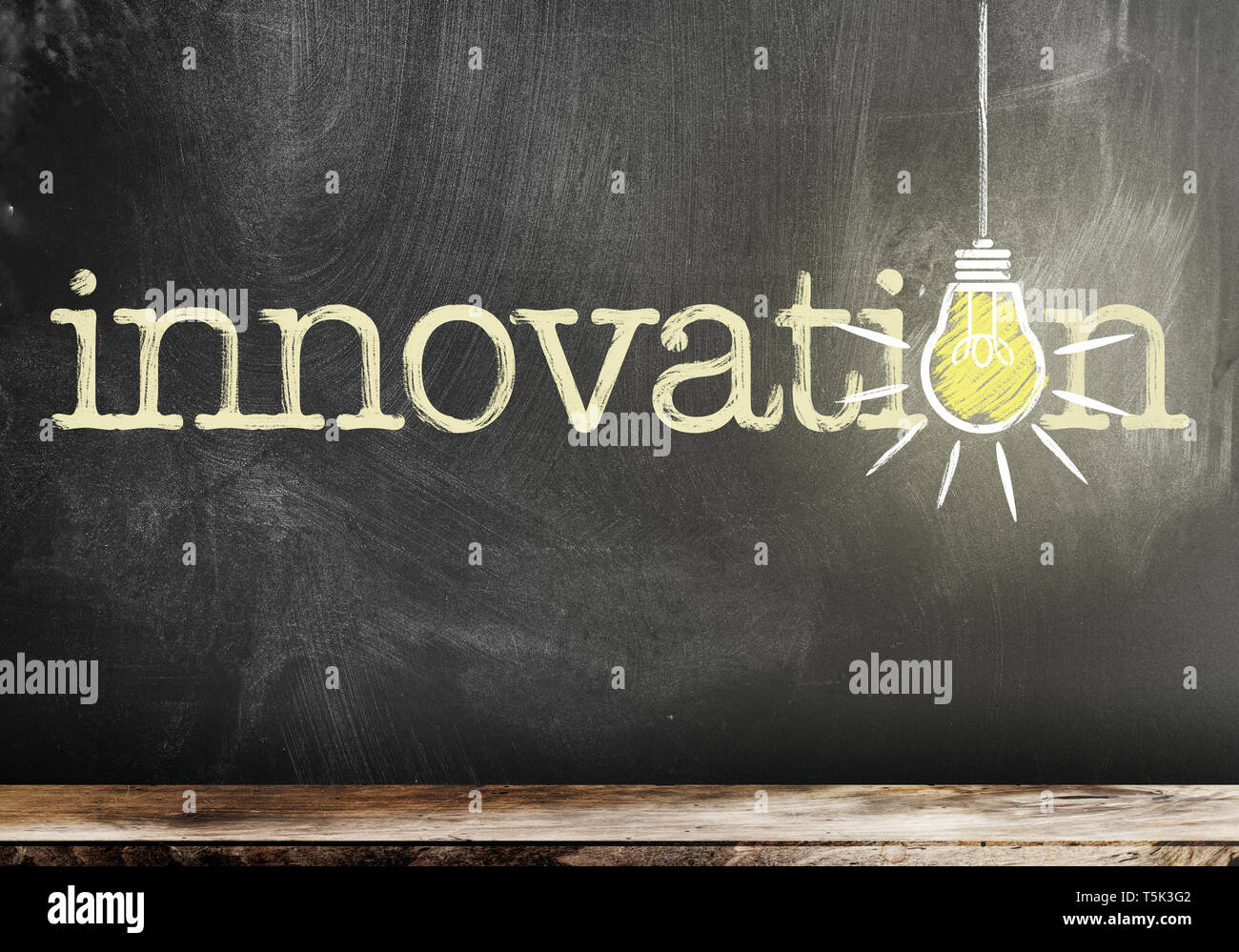 word innovation on chalkboard with glowing light bulb symbolizing and idea Stock Photo