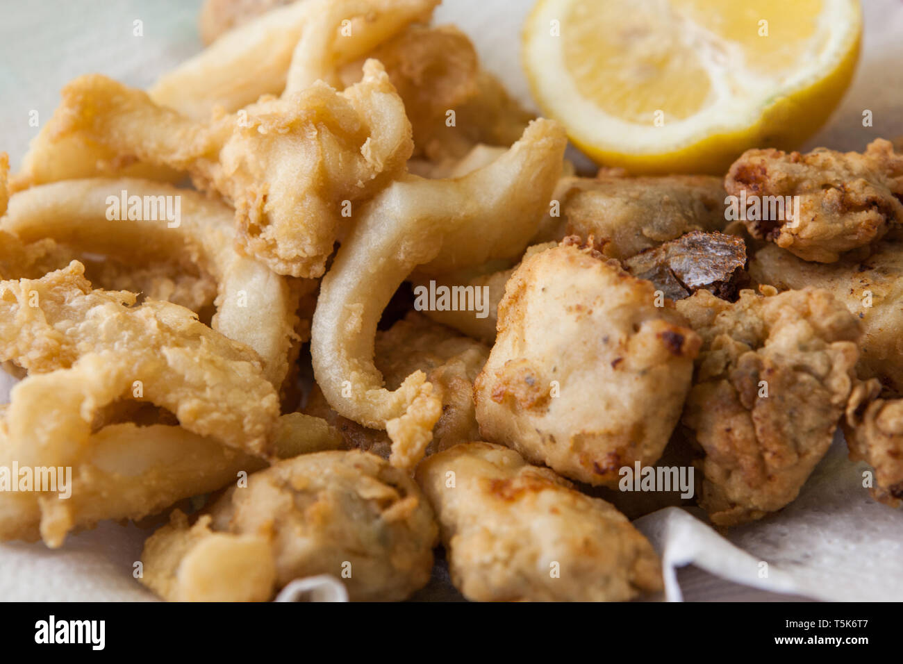 deep fried squid and fish on olive oil with lemon Stock Photo