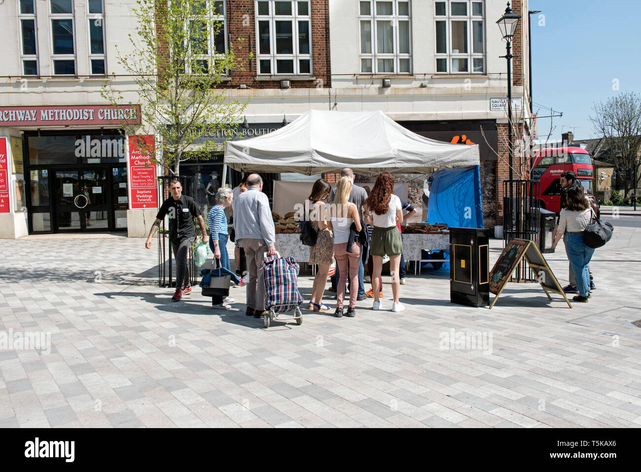 People queuing to buy bread in front of Celtic Bakers stall on Navigator Square Archway N19 formally Archway Roundabout Stock Photo