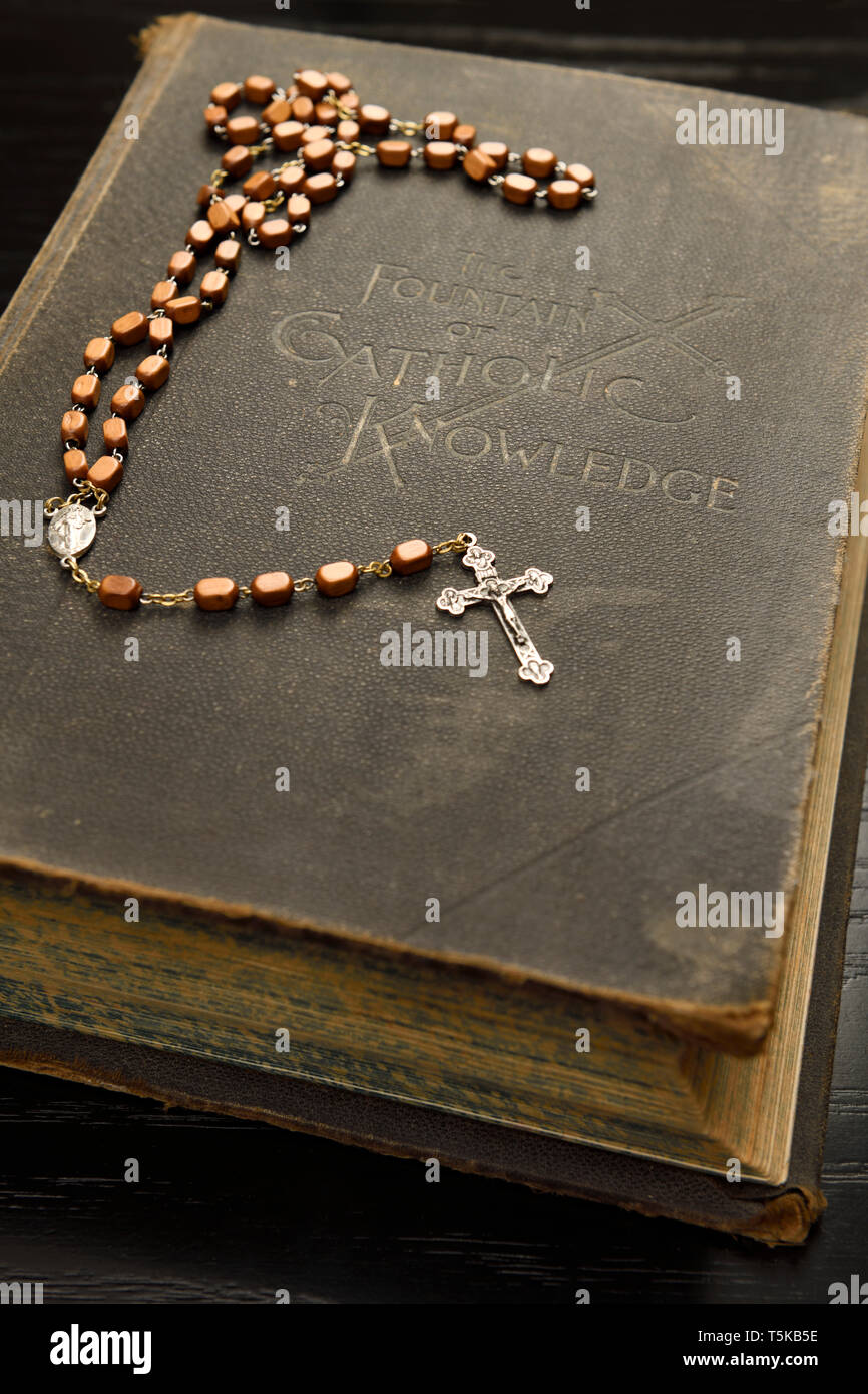 Ancient book on The Fountain of Catholic Knowledge with a holy rosary lying on the cover Stock Photo