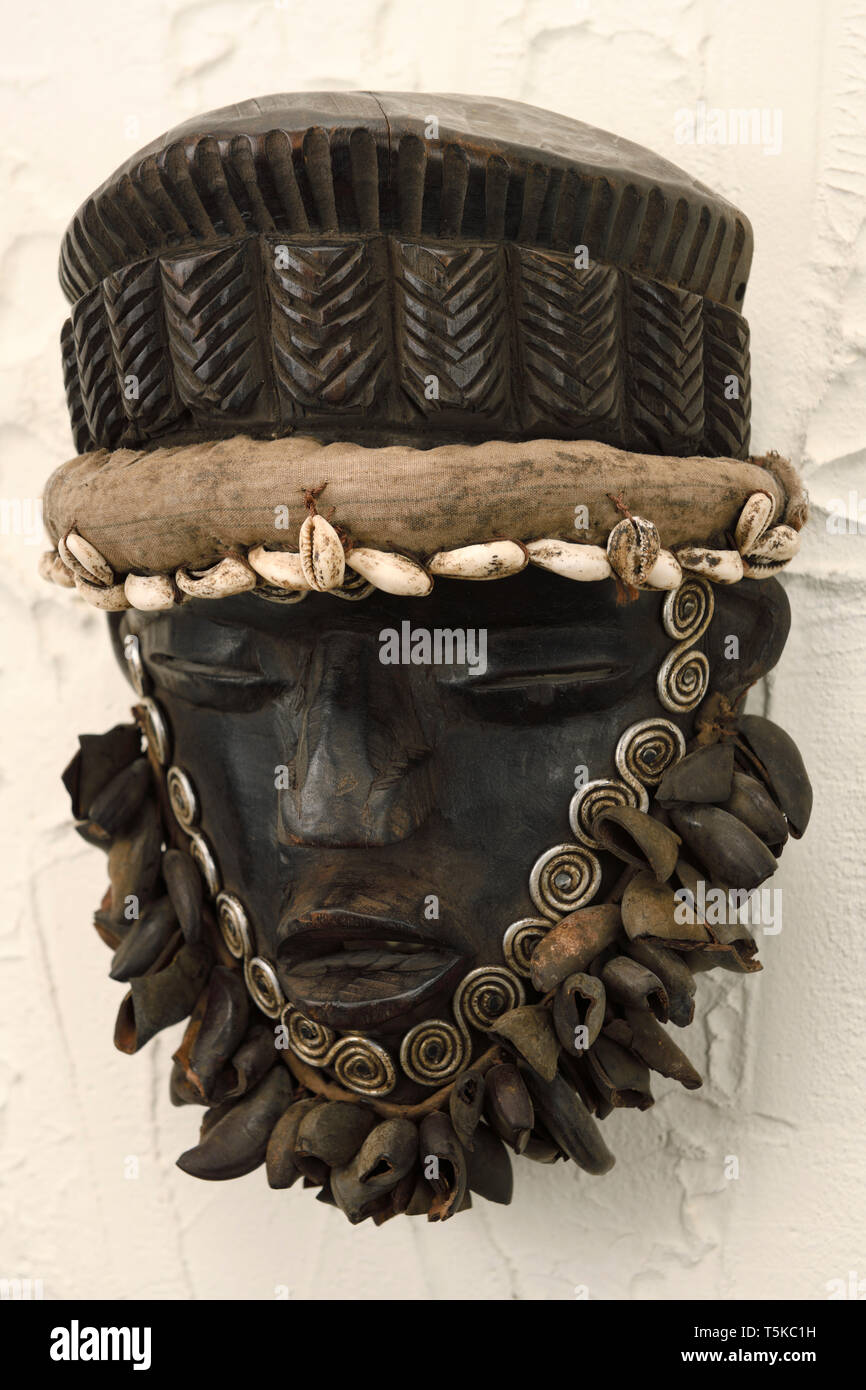 West African wood carved Dan Ceremonial dance mask with shells Stock Photo