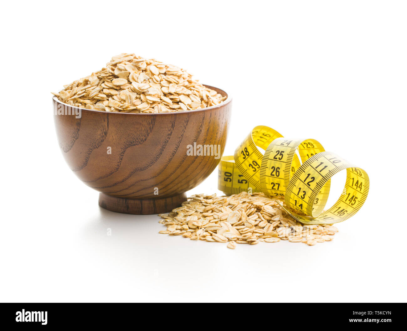 Dry rolled oatmeal and measuring tape isolated on white background. Stock Photo