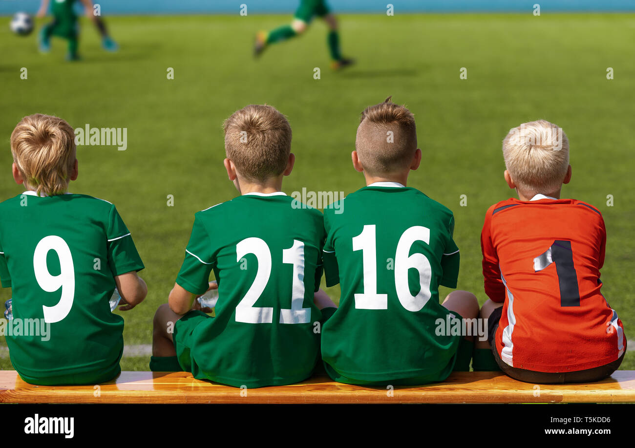 Children Sitting on Soccer Football Wooden Bench. Kids Junior Football