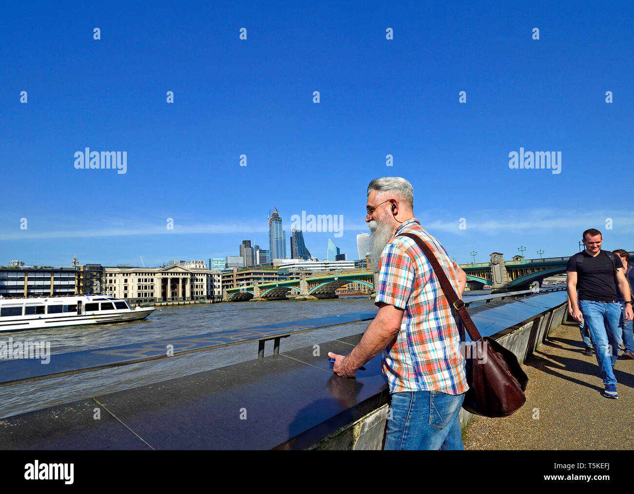 London, England, UK. Bearded man looking out over the River Thames from the South Bank. City of London skyline behind Stock Photo