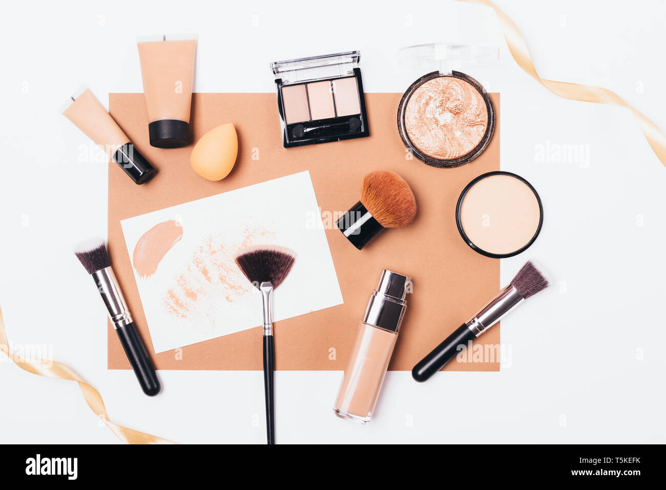 Beauty products and accessories for even complexion, top view. Decorative  cosmetics and makeup brushes with beige silk ribbon on white background  Stock Photo - Alamy