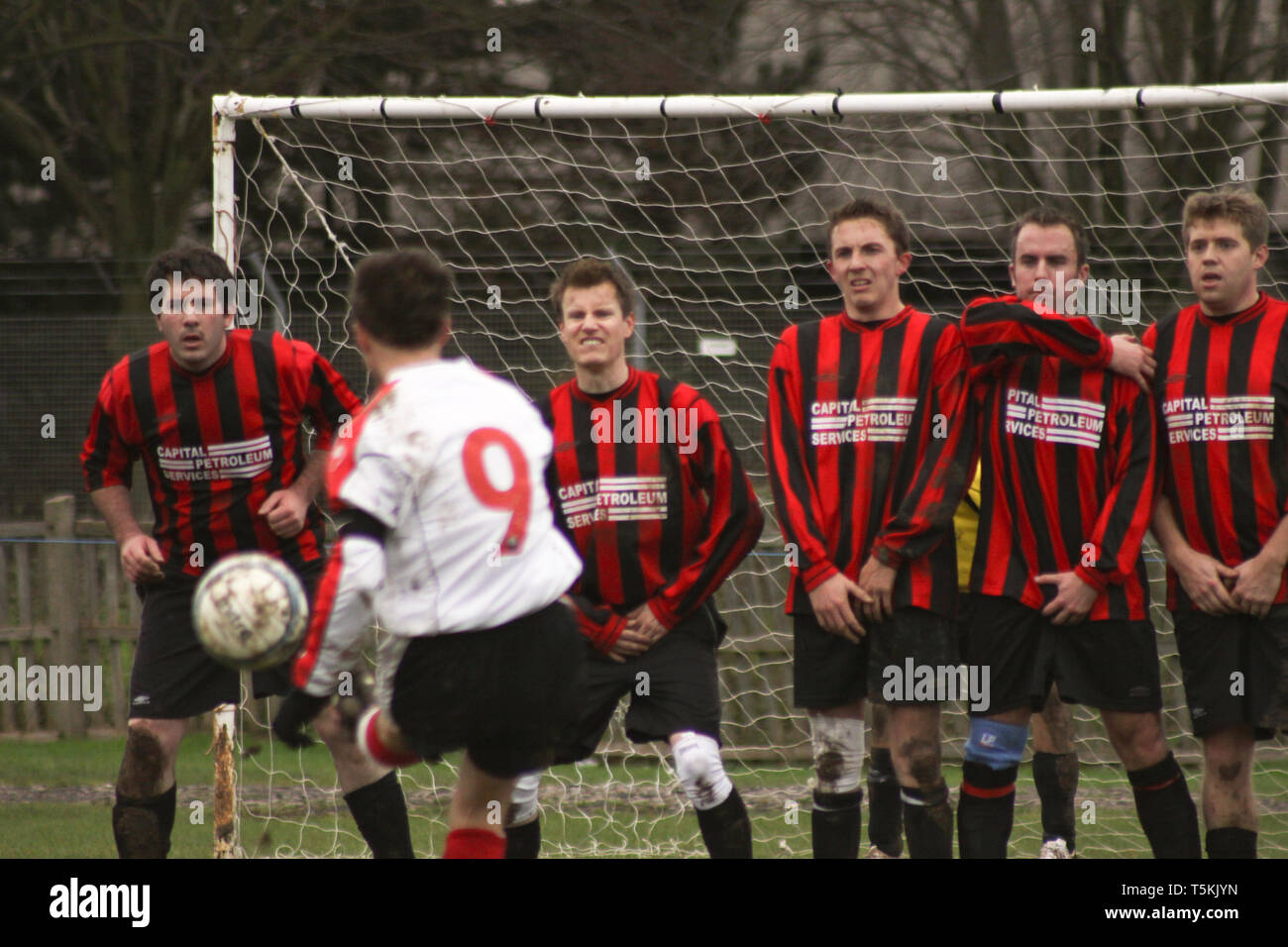 Football team defending a free kick by forming a human wall Stock Photo