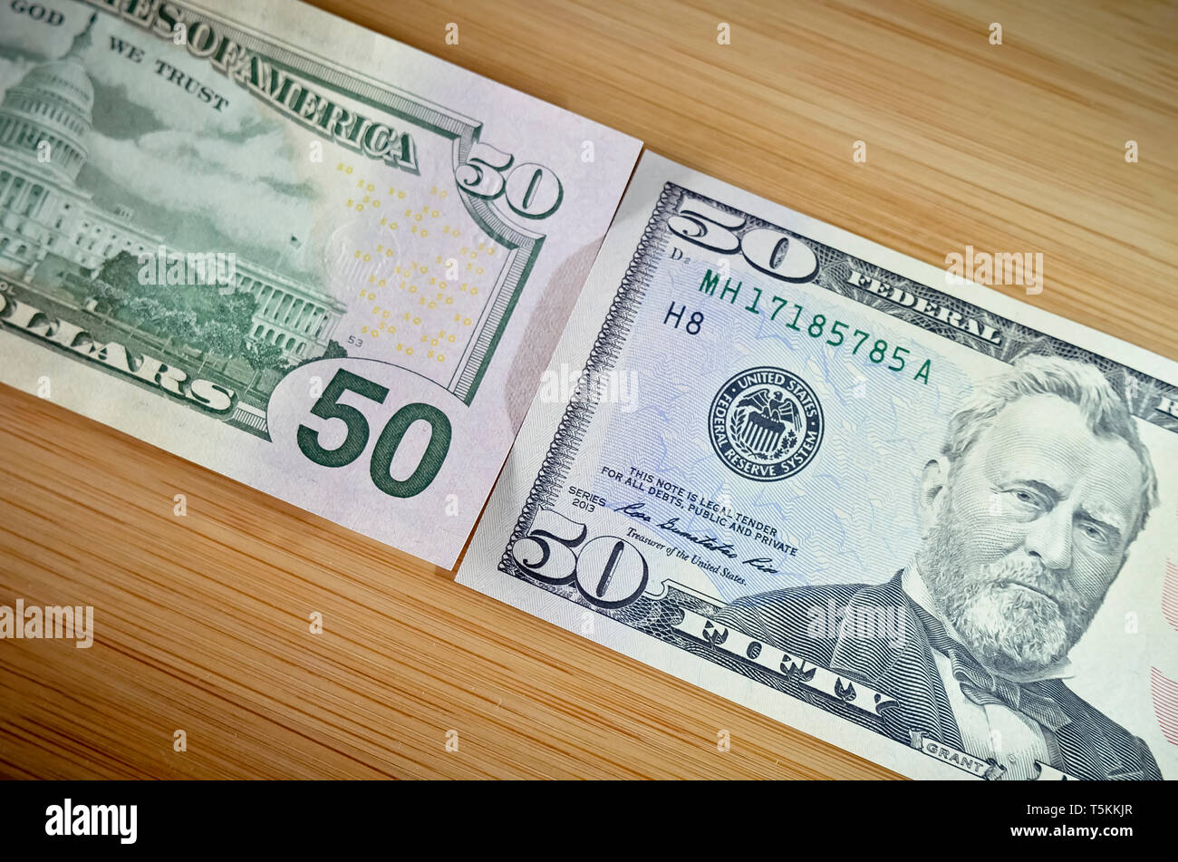 Two Fifty Dollar Bills on Wood Table Stock Photo