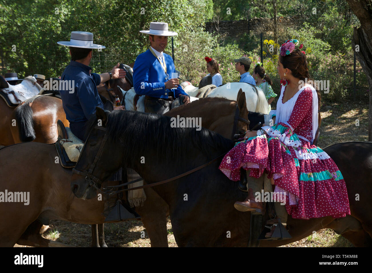 Two men and girl in Spanish clothes at Romeria Stock Photo