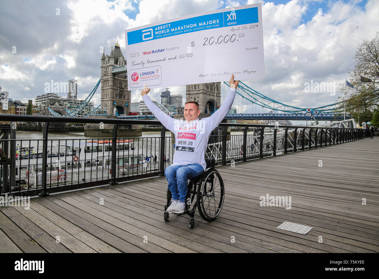 London, UK. 25th Apr, 2019. London Marathon 2019 Chris Miller, Divisional Vise President of Global Brand Strategy and Innovation with Michelle Weltman, Elite wheelchair athlete coordinator for Abbot World majors & London Marathon presenting David Weir with a 20000 thousands dollars check marking the 20th year of the London Marathon for David Weir  Credit: Paul Quezada-Neiman/Alamy Live News Stock Photo