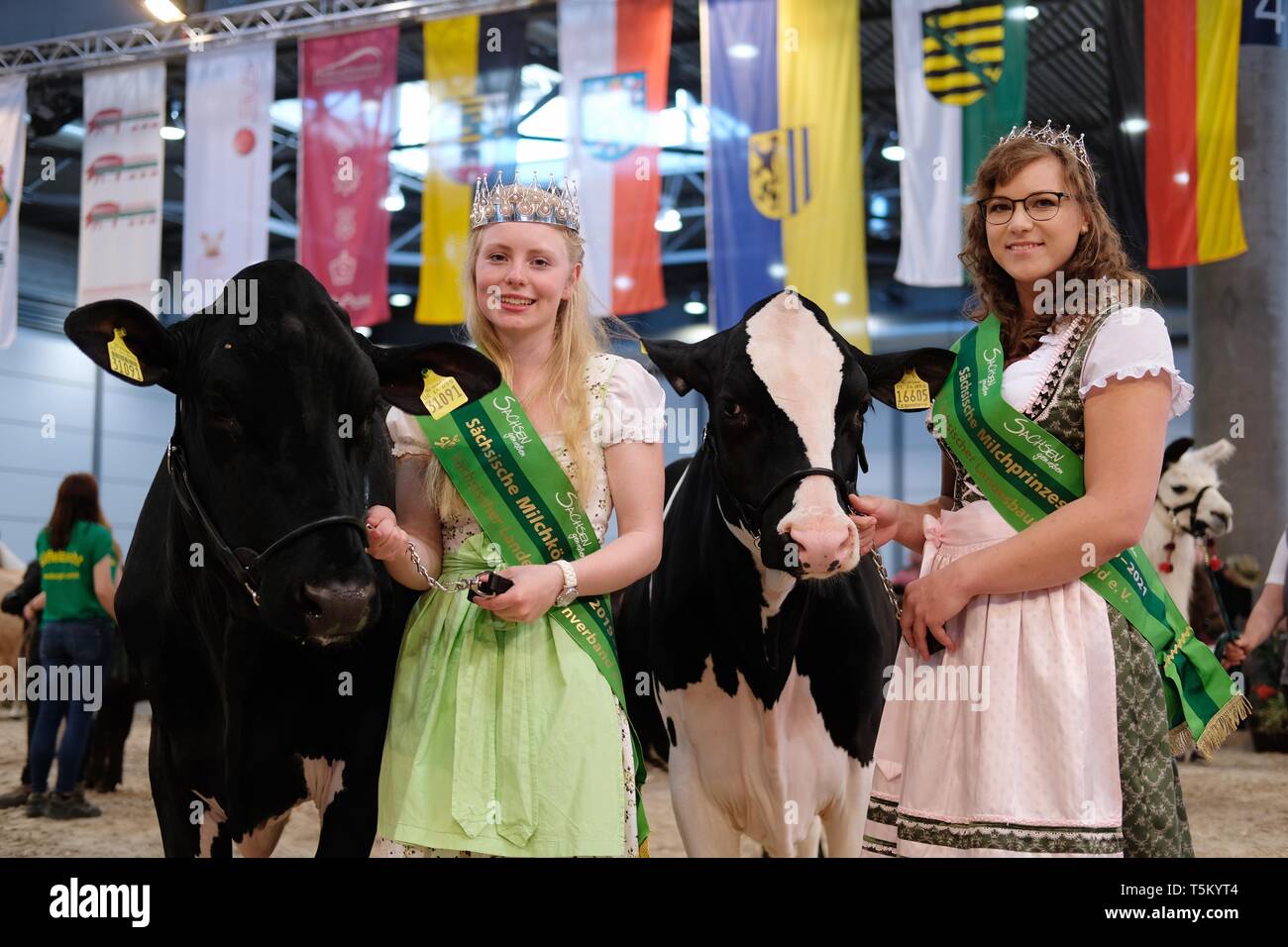 Leipzig, Germany. 25th Apr, 2019. Luisa Hochstein (l) from Schneidenbach in the Vogtland, newly elected Saxon Milk Queen, and Kim Schubert from Werndorf near Glauchau, who was elected Saxon Milk Princess, are standing in a hall of the Leipzig Trade Fair during the agricultural exhibition Agra. Until 28.04.2019, 1,200 exhibitors will be explaining agricultural, forestry and food industry topics. Credit: Sebastian Willnow/dpa-Zentralbild/ZB/dpa/Alamy Live News Stock Photo