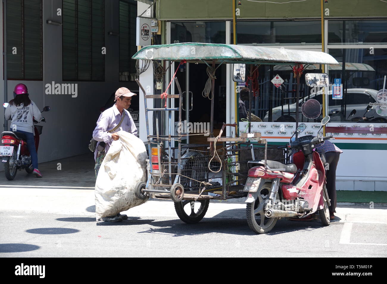 Phuket Stadt, Thailand. 28th Feb, 2019. A man drags a sack to his moped sidecar. Credit: Alexandra Schuler/dpa/Alamy Live News Stock Photo
