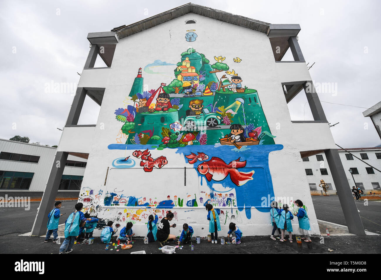 Chun'an, China's Zhejiang Province. 25th Apr, 2019. Children paint the wall of a building at an art zone in Dashu Township of Chun'an County in Hangzhou, east China's Zhejiang Province, April 25, 2019. Artists and art students have been creating artwork in recent days in an art zone transformed from old factory buildings with a total area of over 10,000 square meters. The art zone will be open to public in early May. Credit: Xu Yu/Xinhua/Alamy Live News Stock Photo