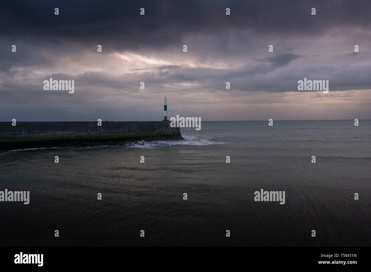 Aberystwyth Wales UK, Thursday 25 April 2019 UK Weather: Dark brooding clouds gather over Cardigan Bay at Aberystwyth, as the latest storm system, Storm Hannah, advances on the UK, bringing winds gusting up to 70mph to western areas this weekeng Photo Credit: keith morris/Alamy Live News Stock Photo