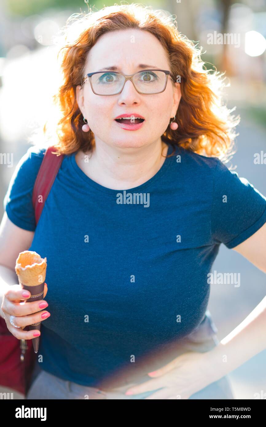 Woman eating ice cream feeling sudden stomach ache gesture