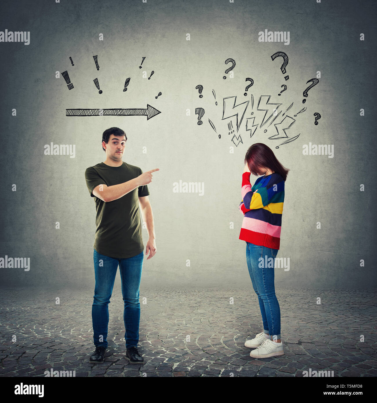 Frustrated man pointing index finger showing to someone. Dissatisfied male forefinger gesture and a worried woman introvert holding hand to forehead.  Stock Photo