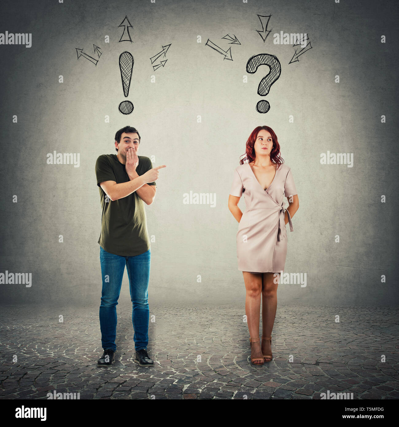 Amused man extrovert, with exclamation sign over head, pointing forefinger to an ashamed woman introvert. Worried girl feeling guilty looking aside ha Stock Photo