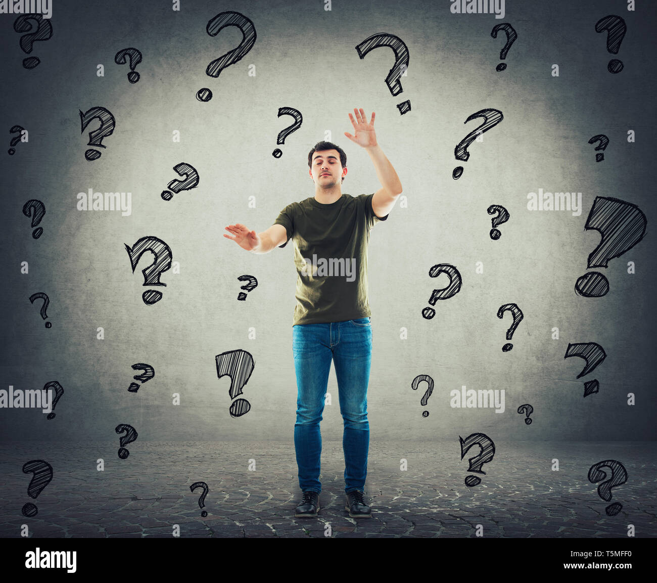 Guy searching with hands outstretched and eyes closed like walking blind in the darkness, surrounded by interrogation marks flying around head. Unsure Stock Photo