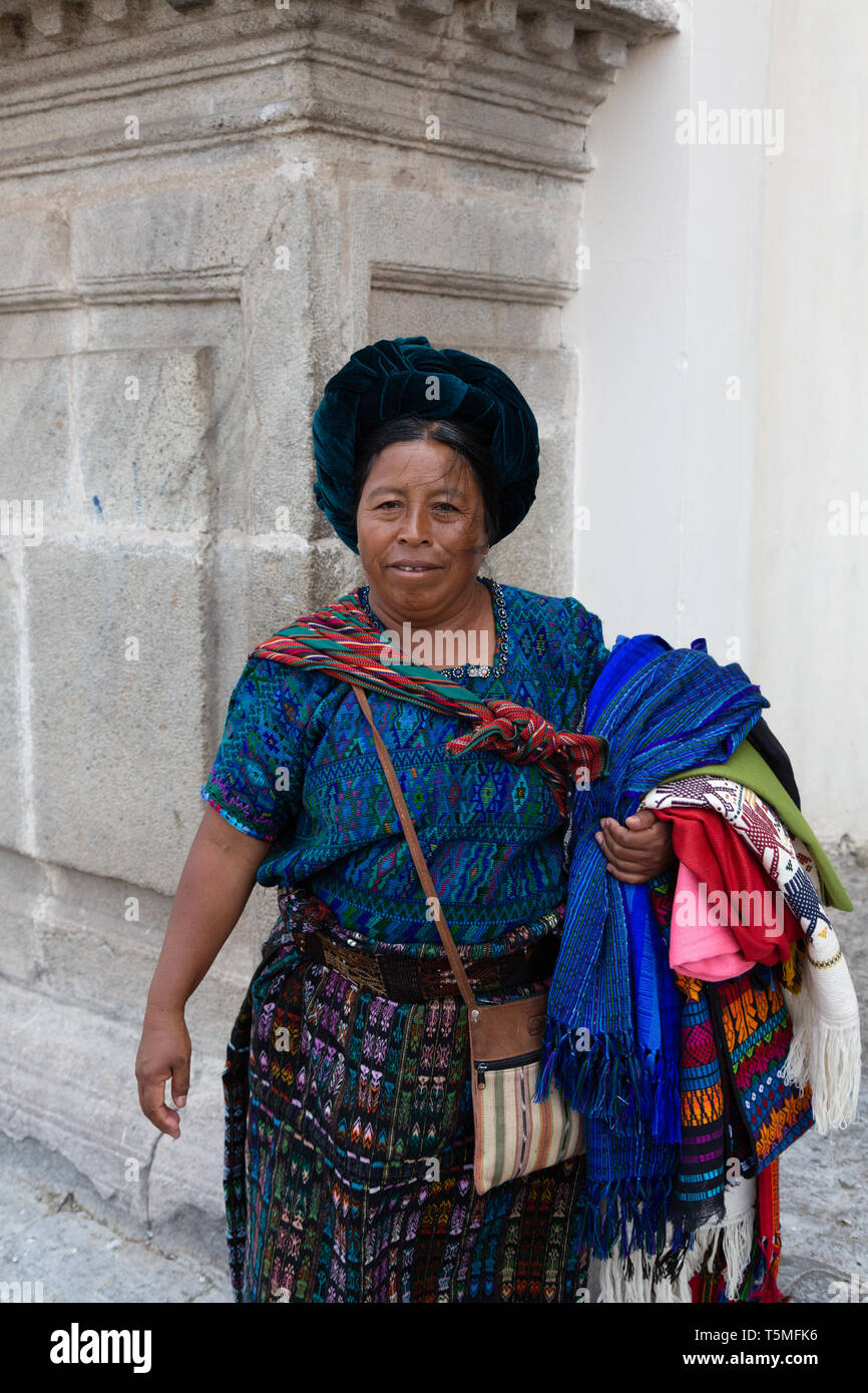 Guatemala lifestyle; Guatemalan woman selling goods and textiles on the street, Antigua Guatemala Central America - example of Latin America culture Stock Photo