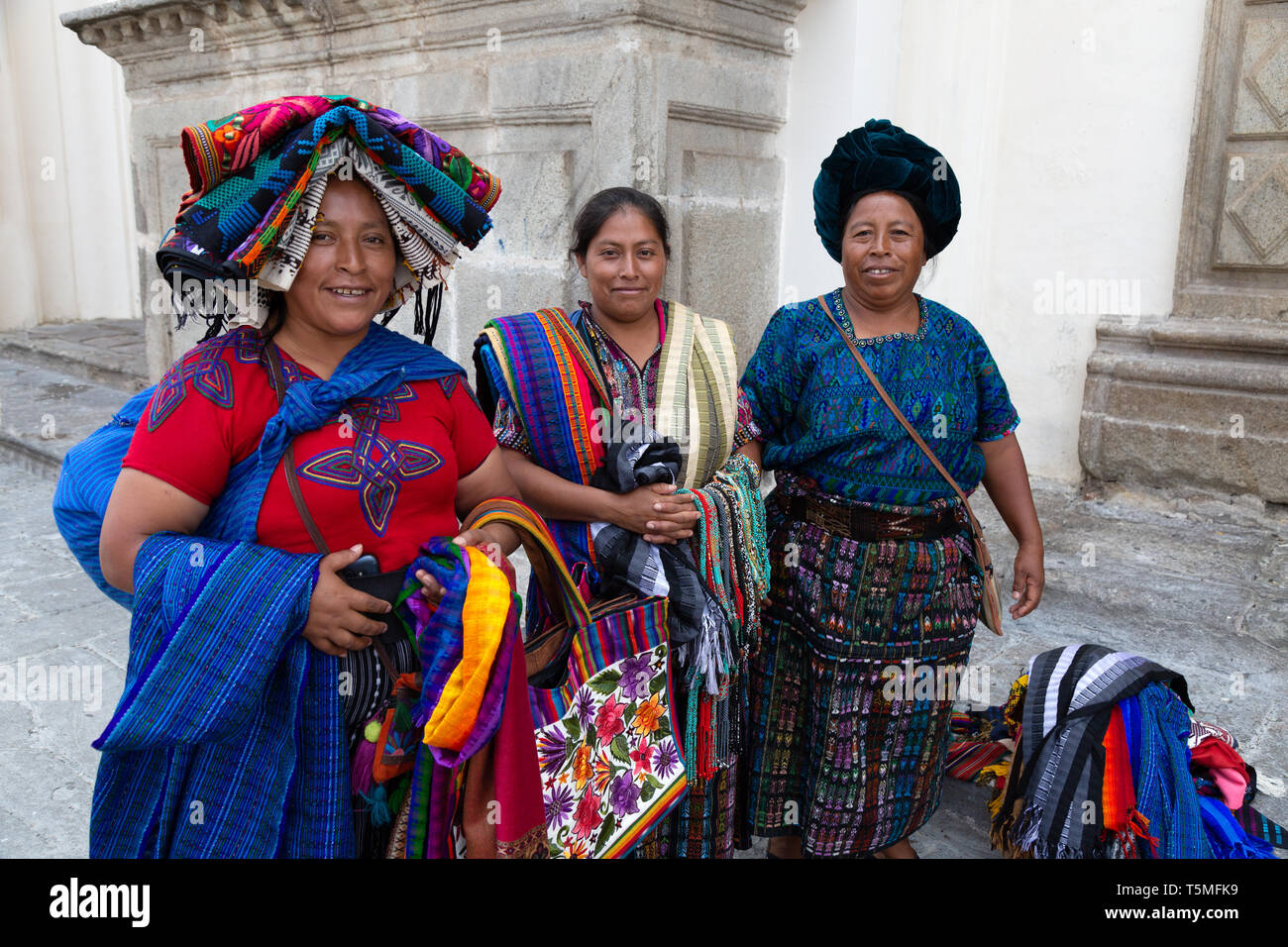 Guatemala lifestyle; Guatemala women selling scarves and textiles on the street, Antigua Guatemala Central America - example of Latin America culture Stock Photo