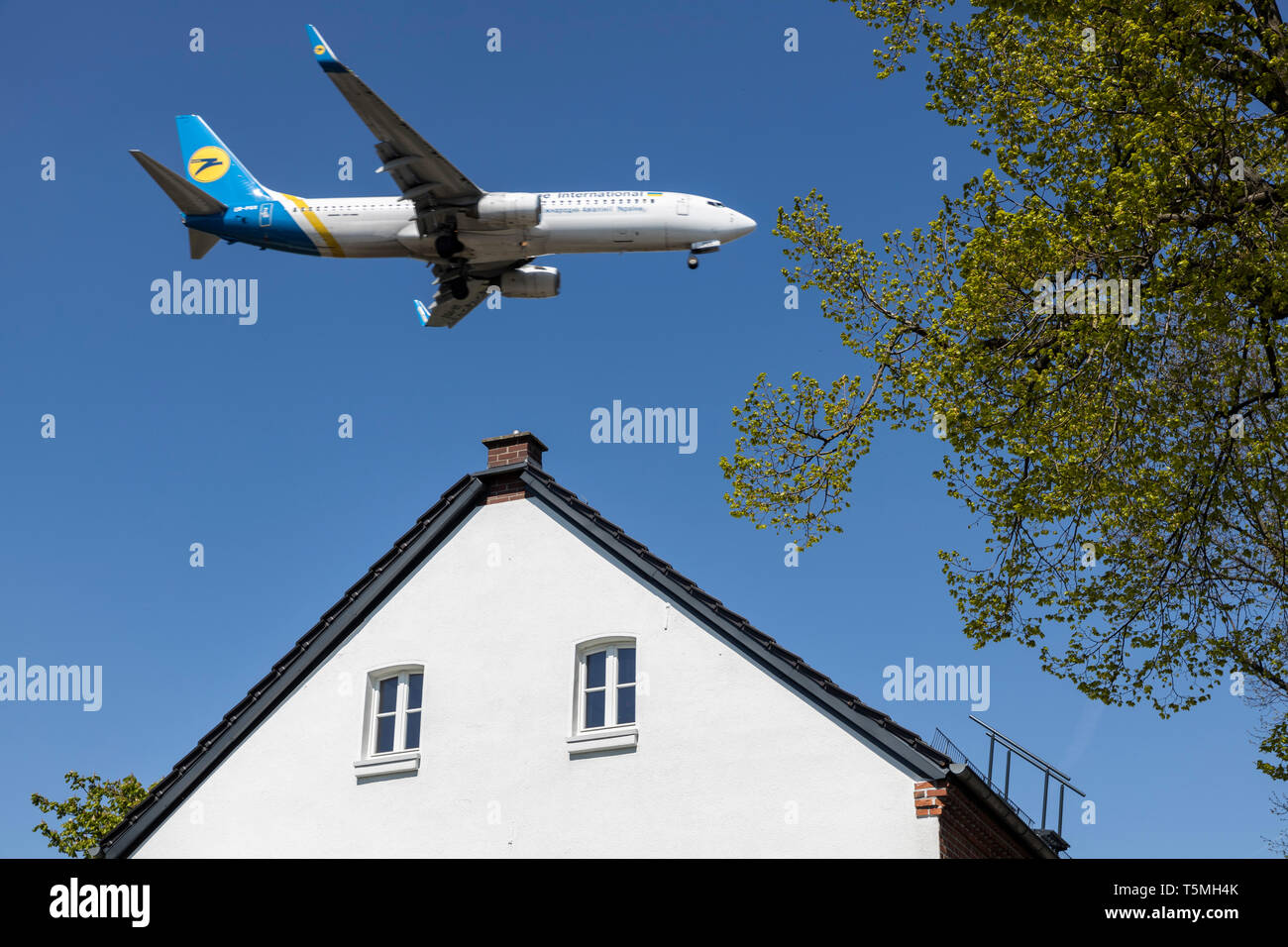 Aircraft landing on DŸsseldorf International Airport, DUS, Germany, houses in Lohausen district, directly at the runway, Stock Photo