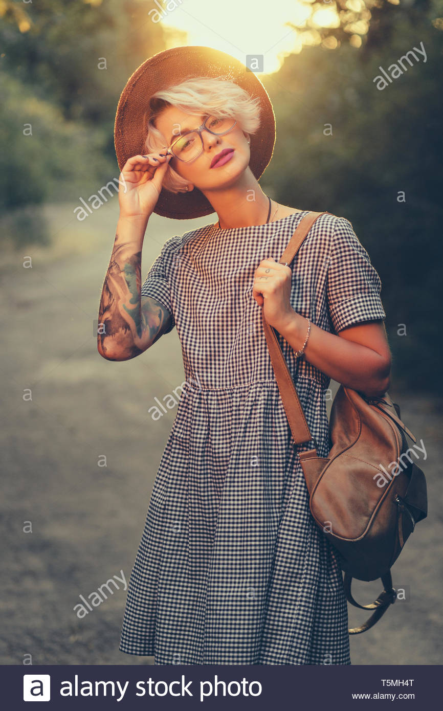 Cute Blonde Girl With Short Haircut Is Walking With Bag In Forest