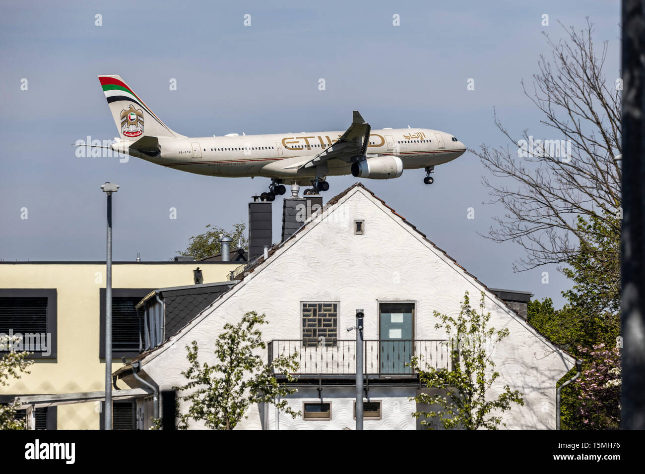 Aircraft landing on DŸsseldorf International Airport, DUS, Germany, houses in Lohausen district, directly at the runway, Stock Photo
