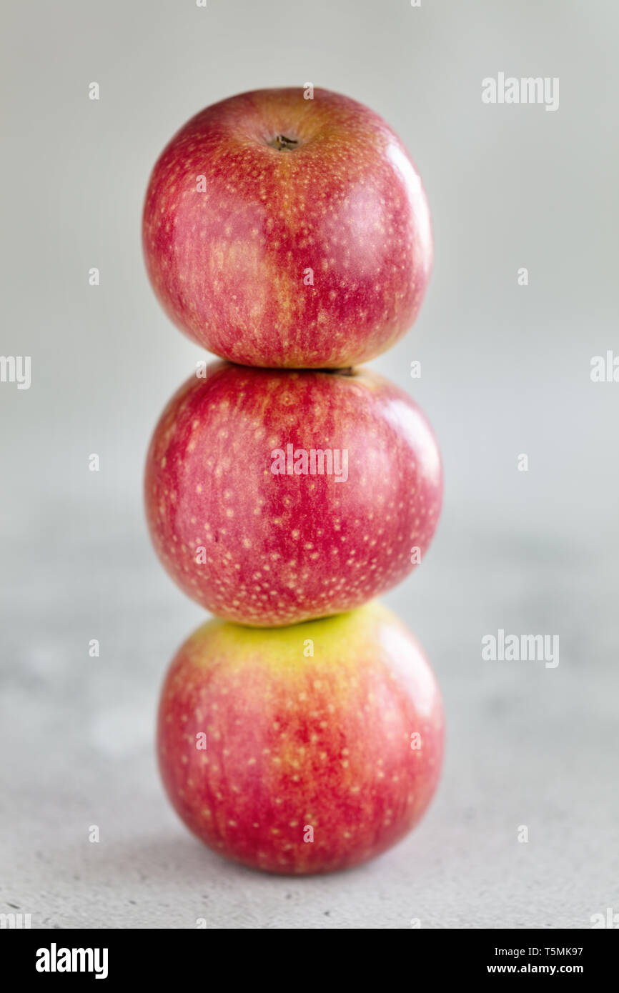 Stack of three apples on light background, vertical composition Stock Photo
