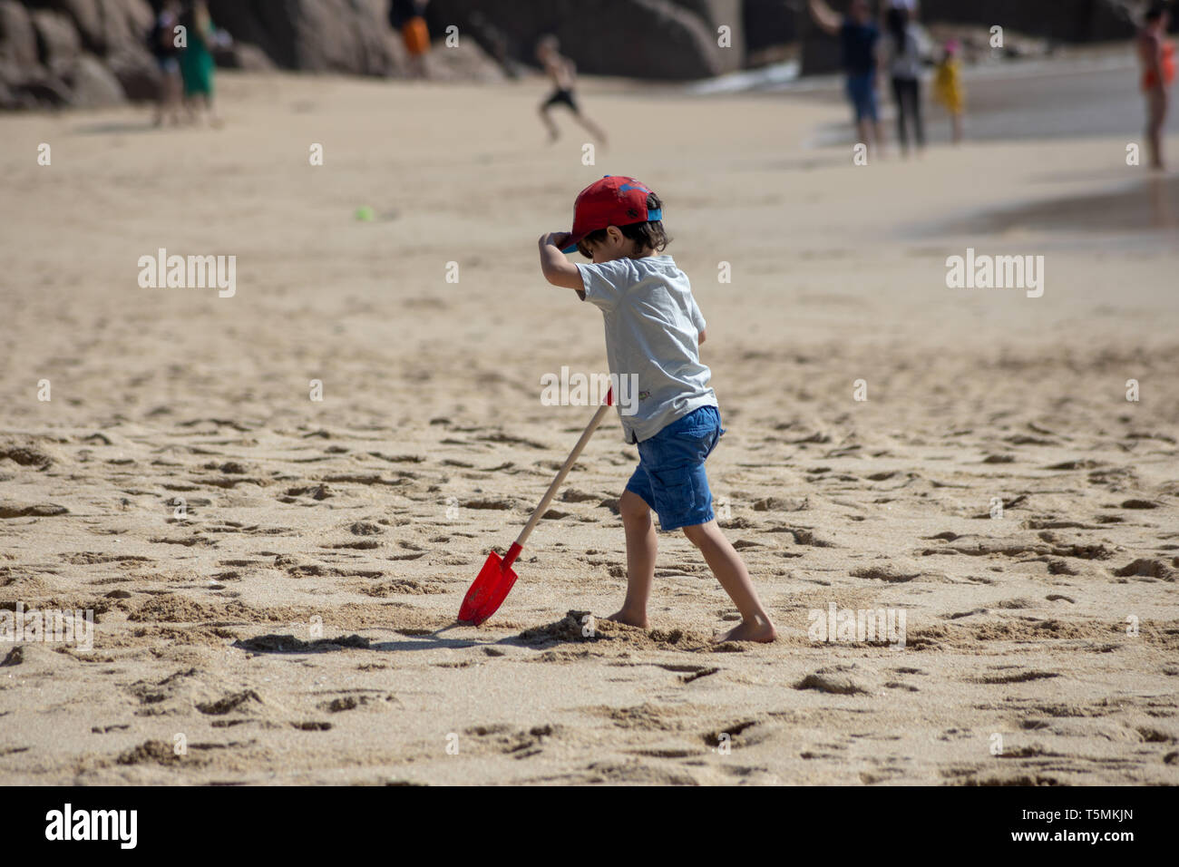small boy walking on beech with his spade Stock Photo - Alamy