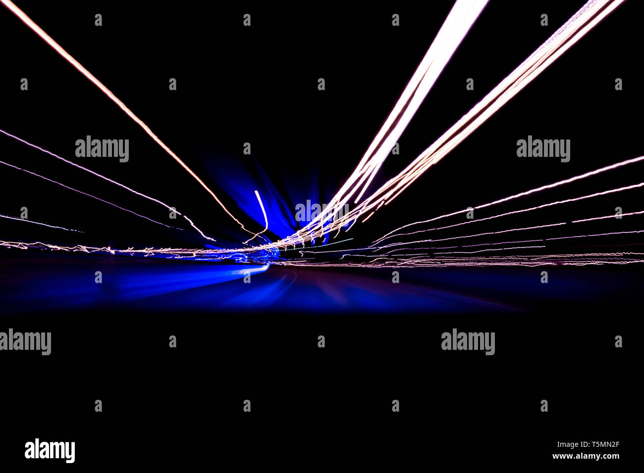 Cars light trails on a curved highway at night. Night traffic trails. Motion blur. Night city road with traffic headlight motion. Cityscape. Light up  Stock Photo