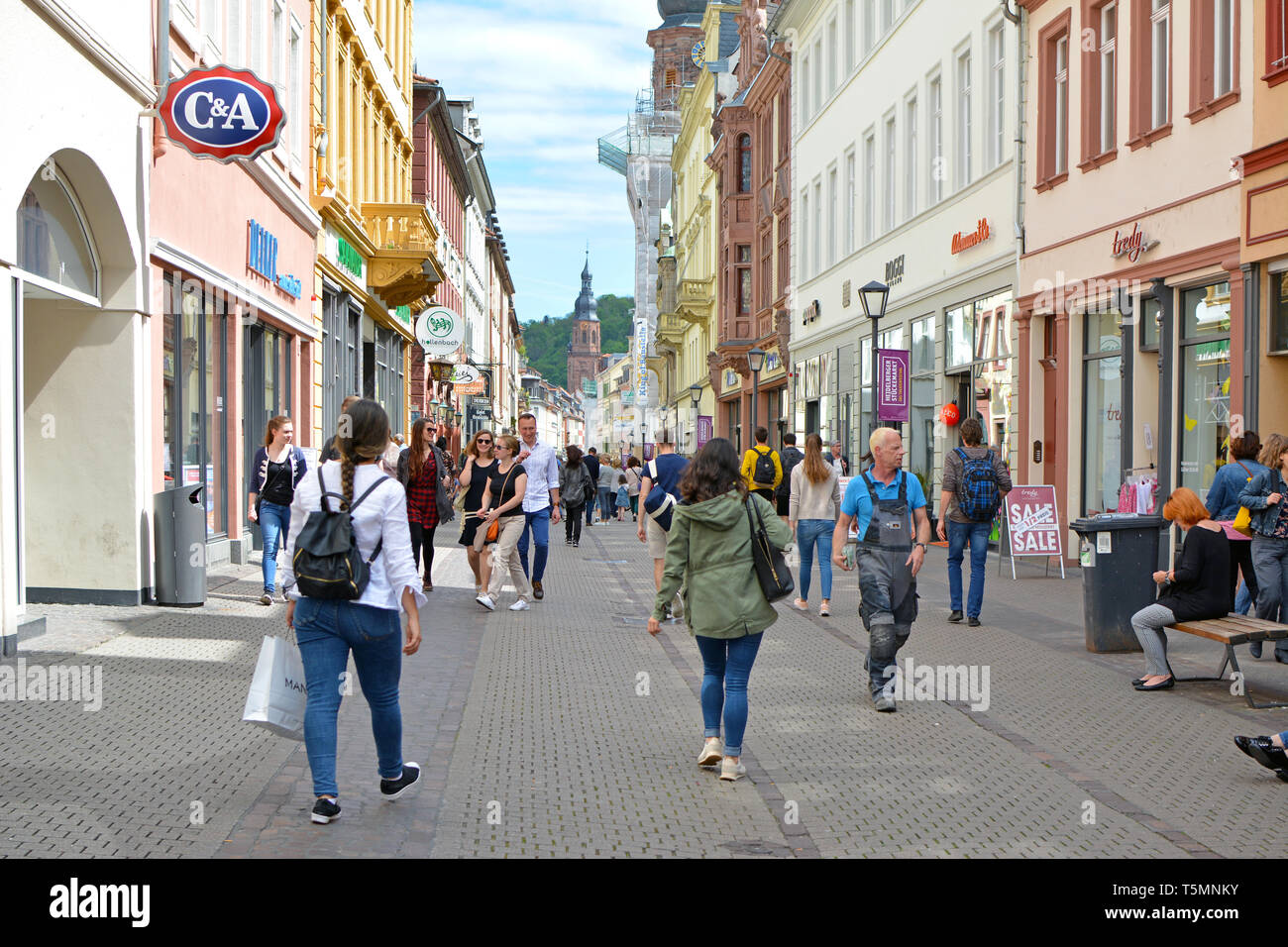 People Walking Down Shopping Main Street On Sunny Spring Day In