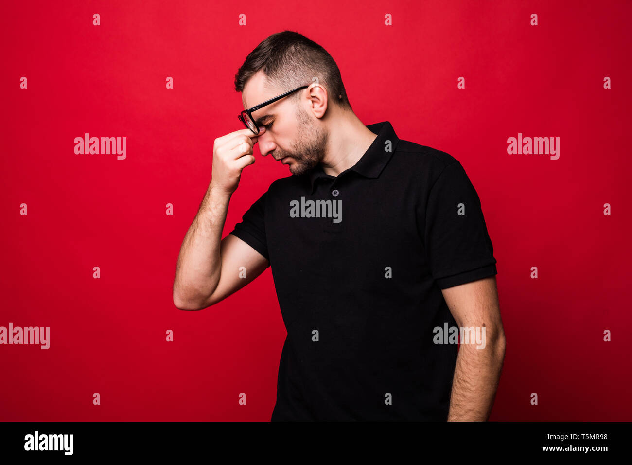 Young man tired isolated on red background Stock Photo