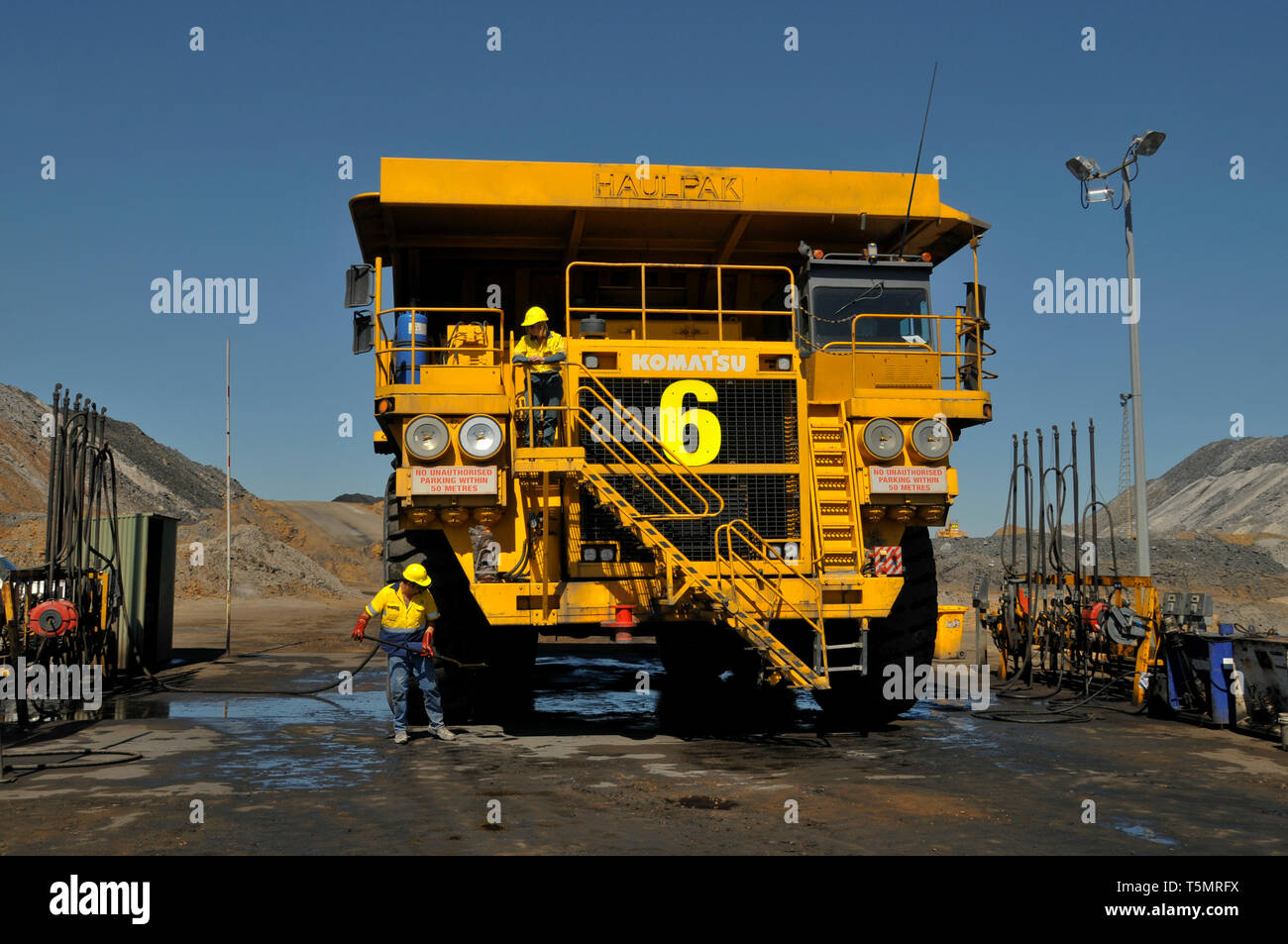 A fronton view of a Haulpac coal transport truck, undergoing a high pressure wash, at a coal mine site. Stock Photo