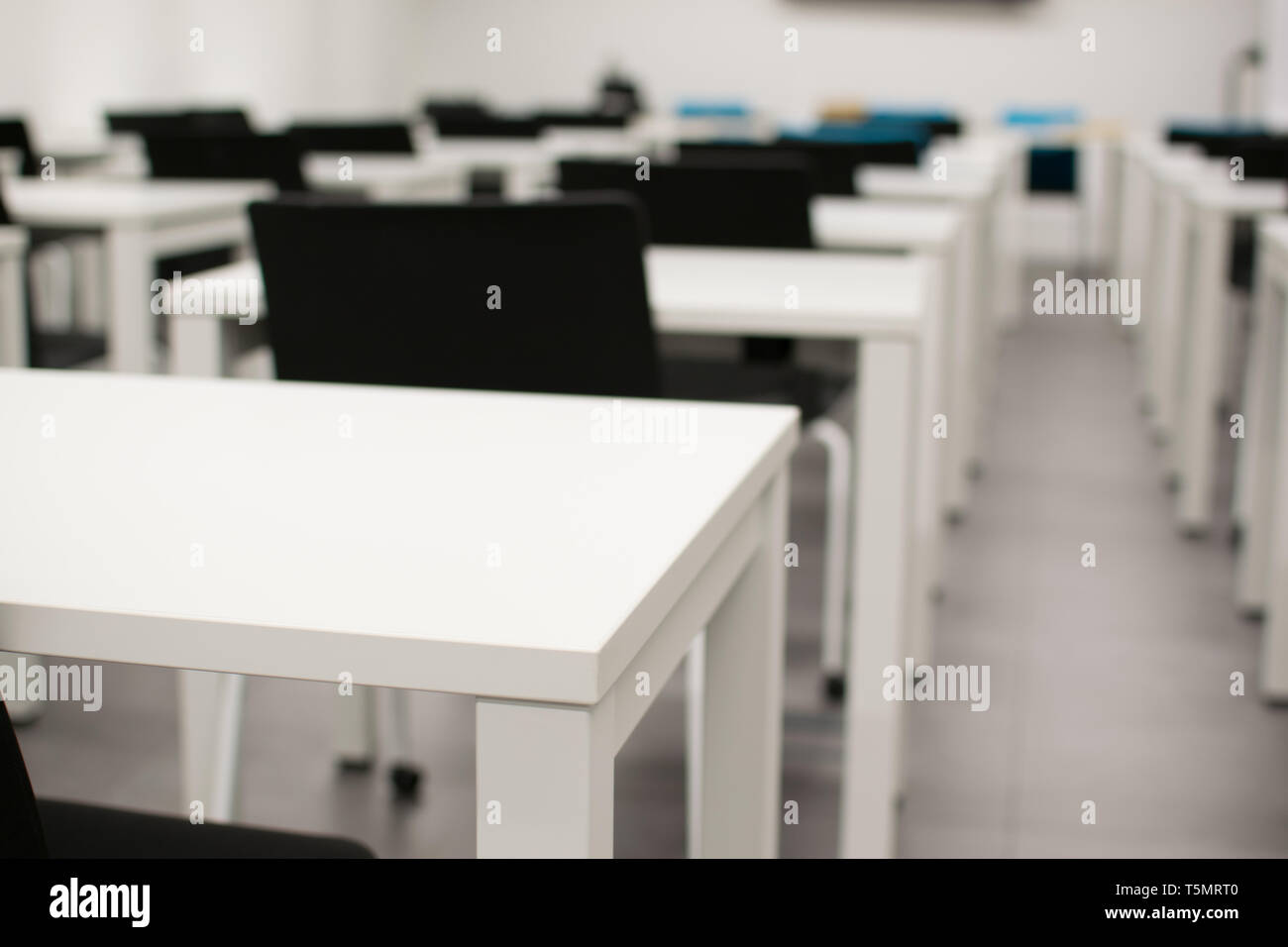 Classroom empty. High school or university desk or table and chairs in a row. Exam test room Stock Photo
