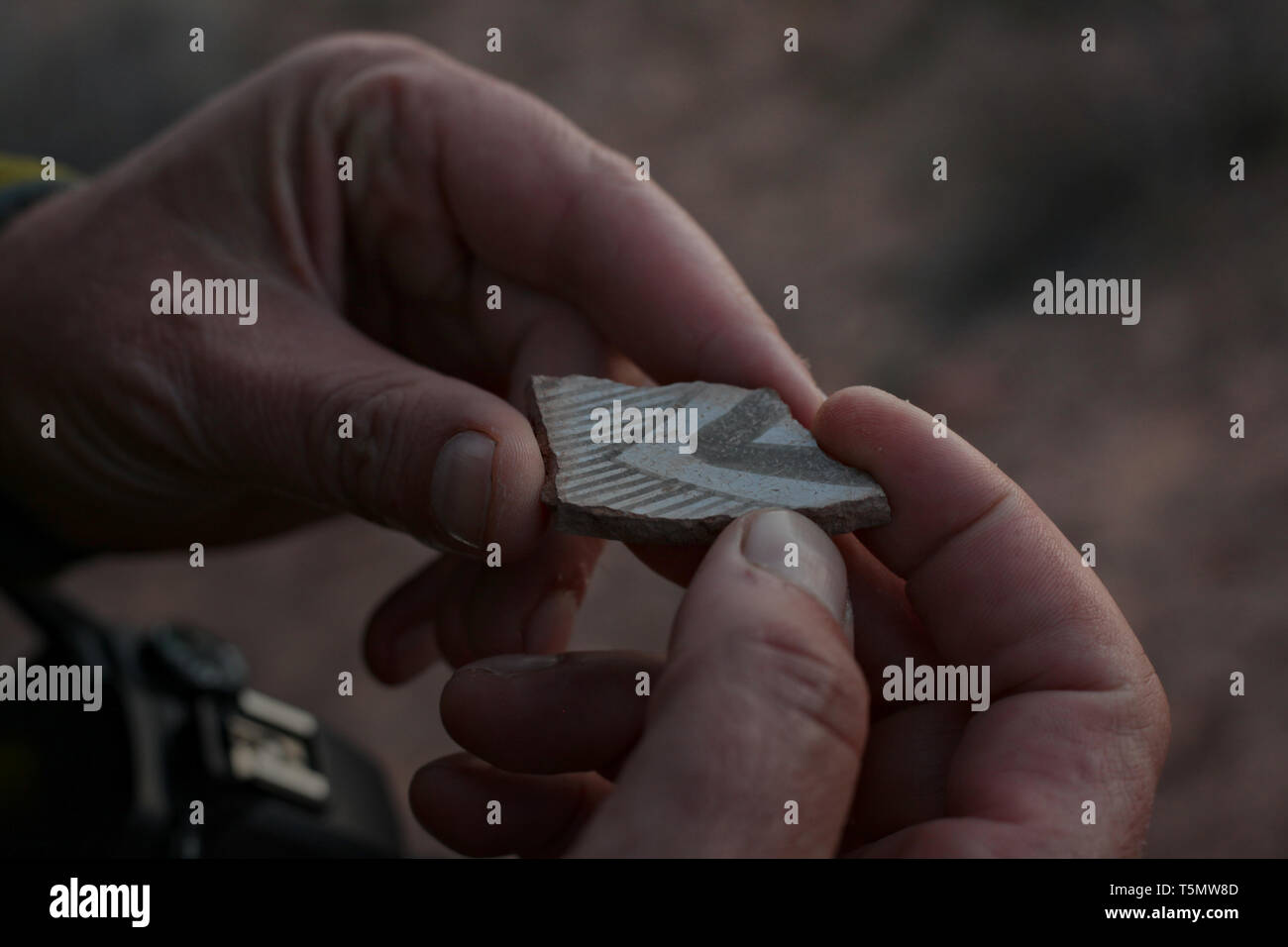 Inspecting a pot-shard in Southeast Utah Stock Photo