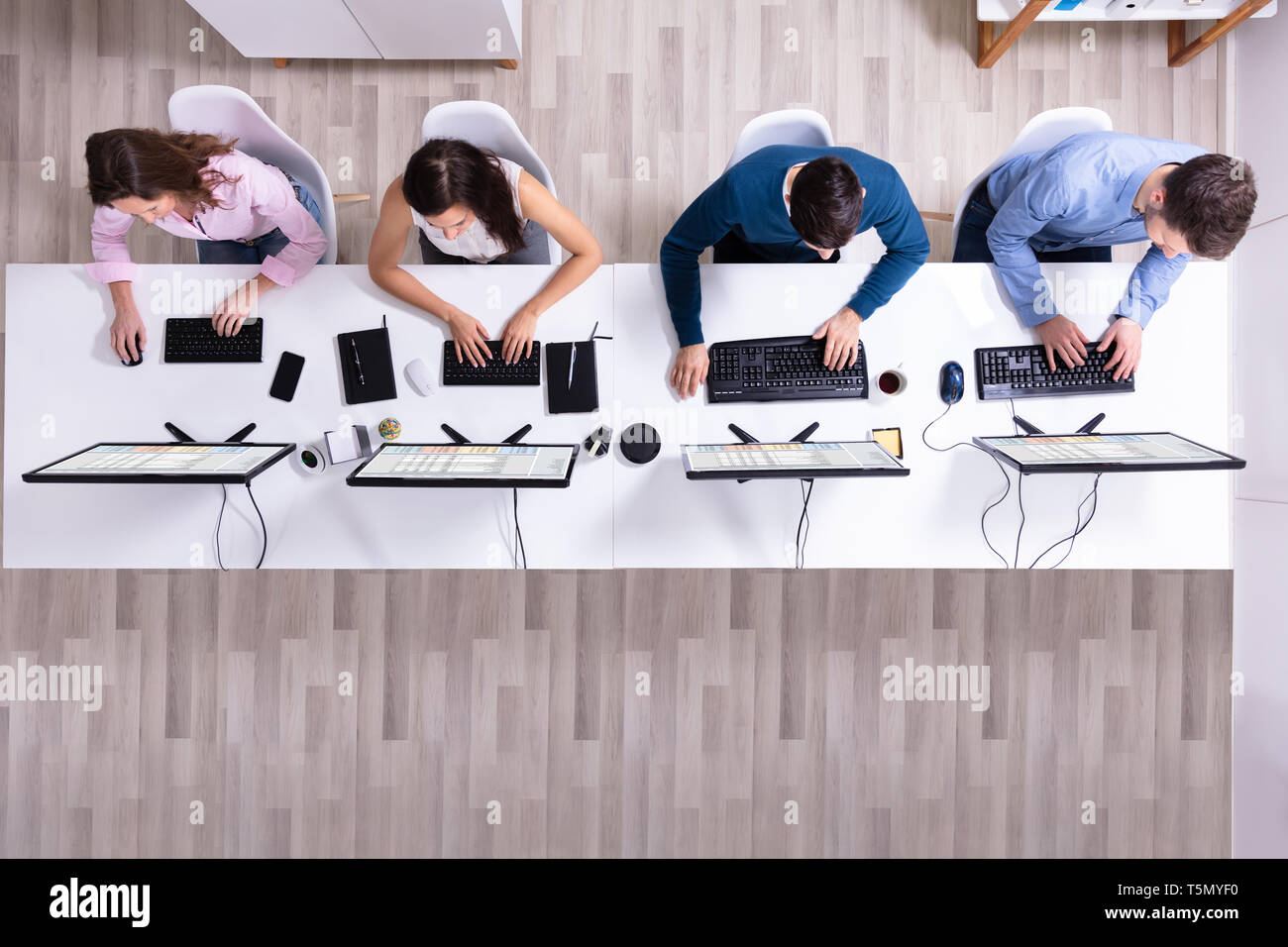 Young Businesspeople Analyzing Gantt Chart On Computer At Workplace Stock Photo